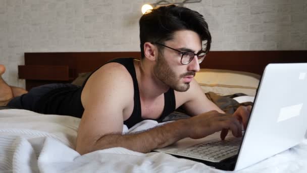 Young Man Doing Homework on Laptop in Bedroom — Stock Video