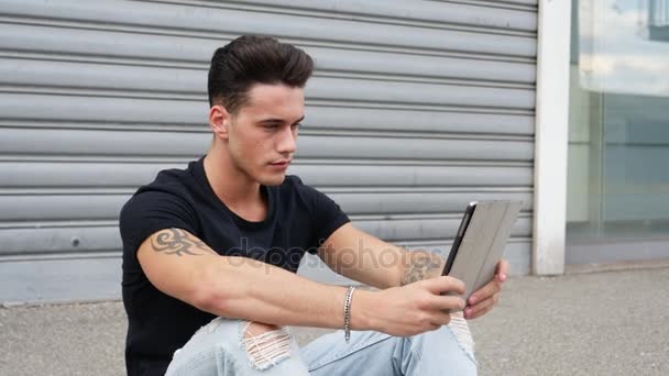 Young man using tablet PC outdoor in city — Stock Video