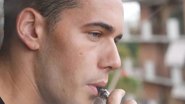Man smoking ecig on balcony — Stock Photo, Image