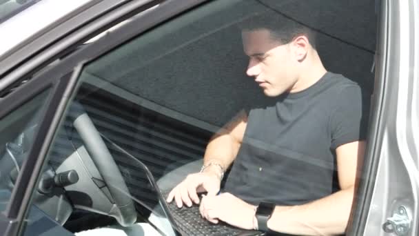 Joven trabajando en el ordenador en su coche — Vídeos de Stock