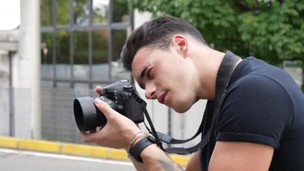 Przystojny młody mężczyzna fotograf biorąc fotografii — Wideo stockowe