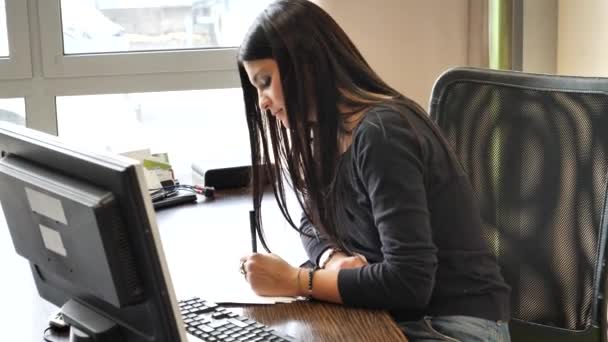 Elegante mujer de negocios sentada en su escritorio trabajando — Vídeos de Stock