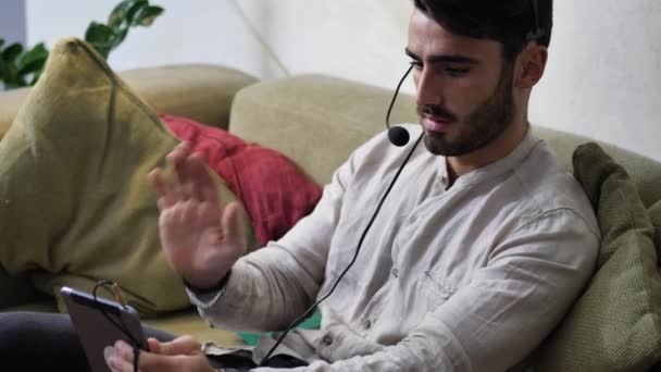 Mężczyzna siedzący w pomieszczeniu wideo rozmowy z tablet Pc — Wideo stockowe