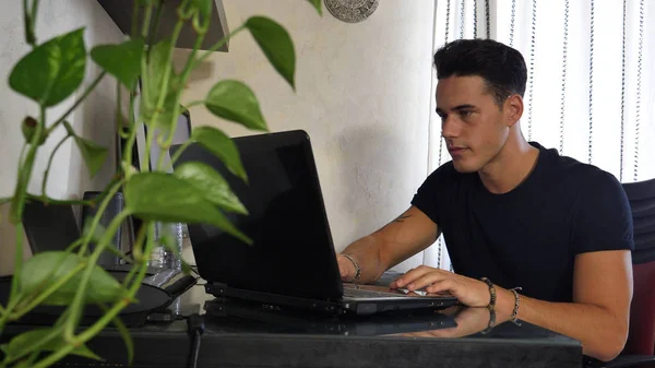 Hombre joven trabajando en computadoras portátiles y de escritorio —  Fotos de Stock