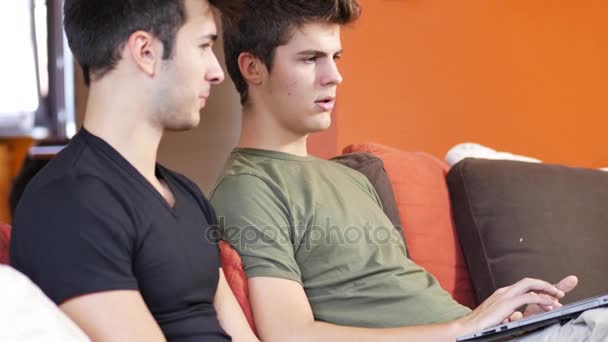 Due giovani amici maschi che utilizzano il computer portatile — Video Stock