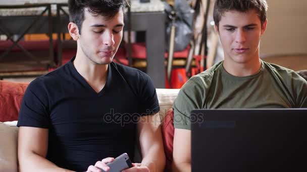 Dois jovens amigos do sexo masculino usando computador portátil — Vídeo de Stock