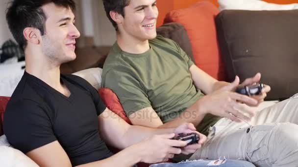 Jovens amigos jogando videogames com joysticks — Vídeo de Stock