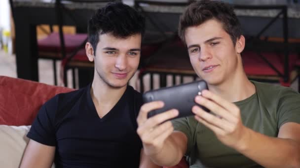 Jeune homme partage smartphone avec un ami — Video