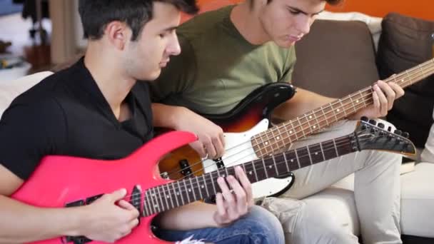 Hombres jóvenes tocando guitarras eléctricas — Vídeo de stock