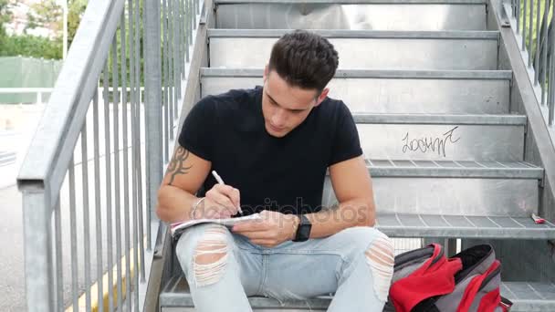 Młody człowiek pisze na arkuszu papieru piórem — Wideo stockowe