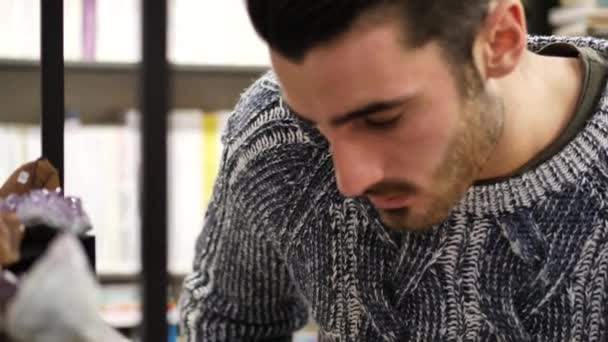 Man looking at goods in shop, an amethyst crystal — Stock Video