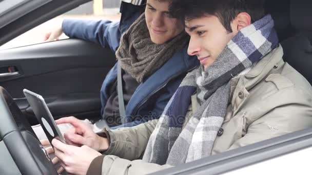 Deux jeunes amis masculins utilisant un ordinateur tablette en voiture — Video