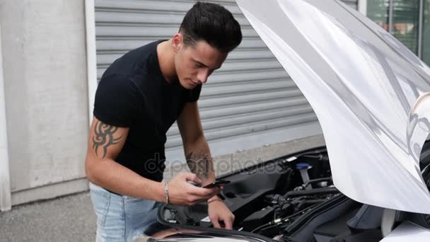 Hombre tratando de arreglar su coche — Vídeos de Stock