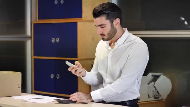 Joven hombre de negocios recibiendo teléfono y hablando — Vídeos de Stock