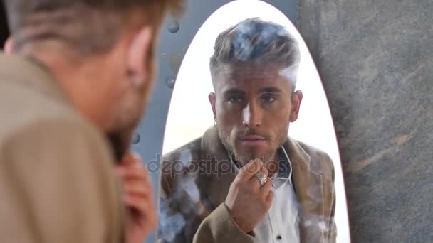 Knappe jonge man en zijn spiegelbeeld in de spiegel — Stockvideo