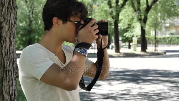 Jovem fotógrafo bonito tirando fotografia — Vídeo de Stock