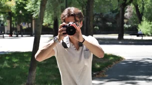 Hermoso joven fotógrafo masculino tomando fotografías — Vídeos de Stock