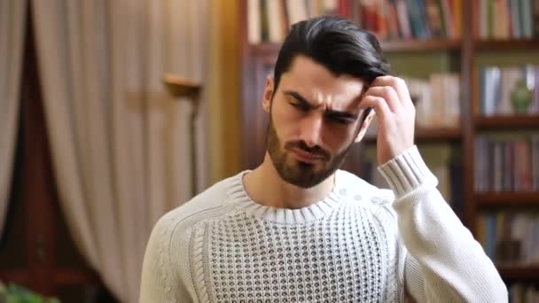 Confused or doubtful young man scratching his head and looking up — Stock Video