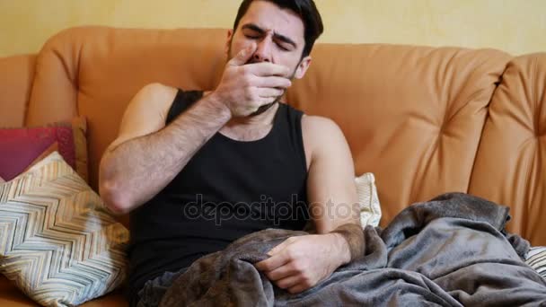 Молодой человек лежит один на диване, спит — стоковое видео