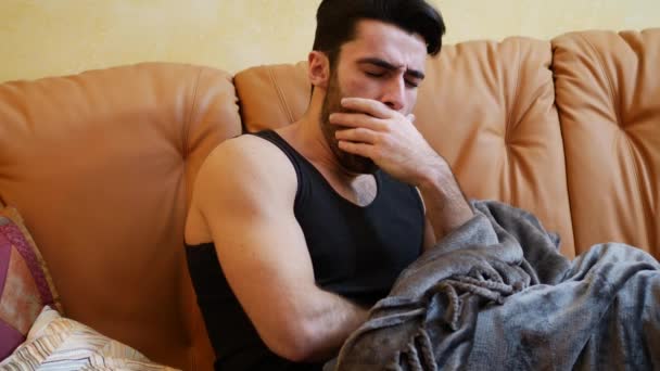 Молодой человек лежит один на диване, спит — стоковое видео