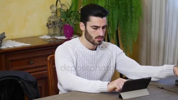 Hombre joven usando tableta PC para ver video o película — Vídeos de Stock