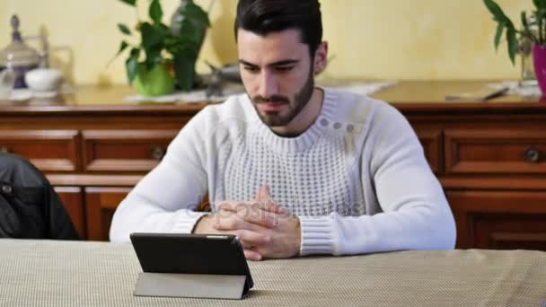 Jovem usando tablet PC para assistir vídeo ou filme — Vídeo de Stock