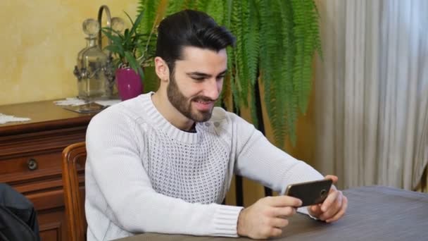 Ελκυστικός νεαρός άνδρας πληκτρολογώντας στο κινητό τηλέφωνο — Αρχείο Βίντεο
