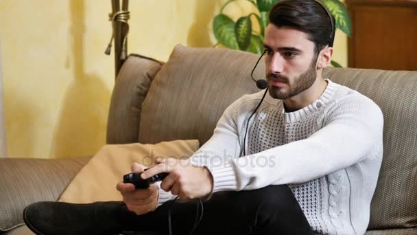 Чоловік грає у відеогру і розмовляє з онлайн-гравцями — стокове відео