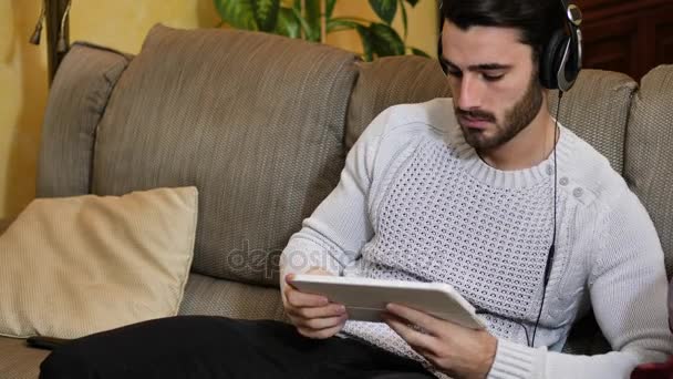 Hombre con auriculares usando tableta PC — Vídeos de Stock