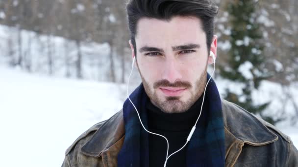 Jeune homme avec smartphone dans la neige — Video