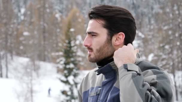 Knappe Zelfverzekerde man in bergen met sneeuw — Stockvideo