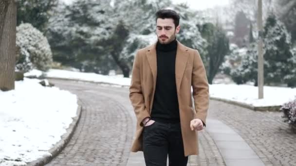 Молодой человек в снежном городе Италии — стоковое видео