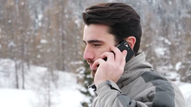 Молодой лыжник разговаривает по телефону — стоковое видео