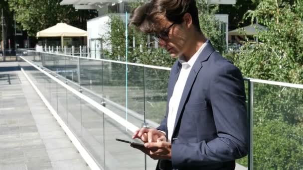 タブレット Pc の屋外を使用して若いビジネスマン — ストック動画