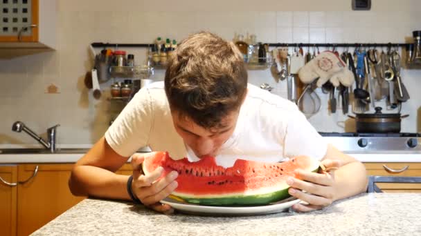 Adolescente do sexo masculino comer melancia em casa — Vídeo de Stock