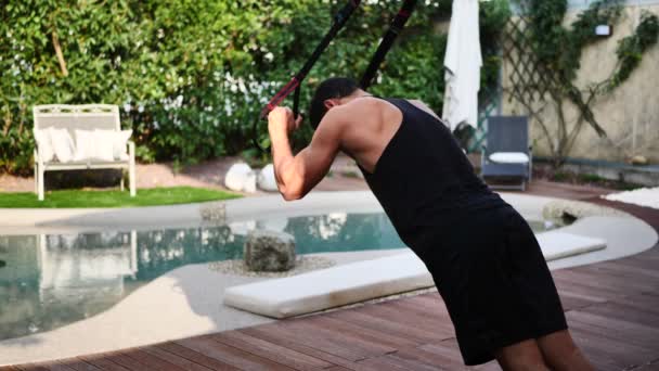 Young fit man using elastic exercise rope outdoor — Stock Video