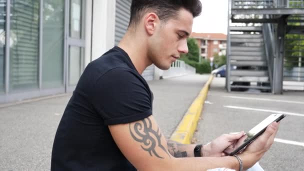 Young man using tablet PC outdoor in city — Stock Video