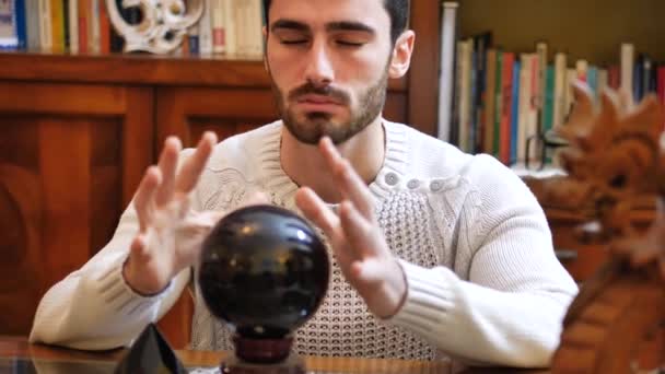 若い男性先見の水晶球を見ることによって未来を予測 — ストック動画