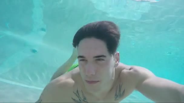 Bonito jovem nadando na piscina, tiro subaquático — Vídeo de Stock