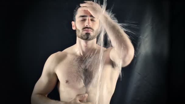 Young Bare Muscular Young Man Receiving Water Splashes in Studio — Stock Video