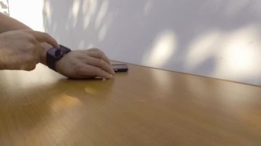 Akıllı saatini ve akıllı telefonu kullanan adam