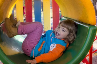 Küçük kız oyun alanında oynuyor.