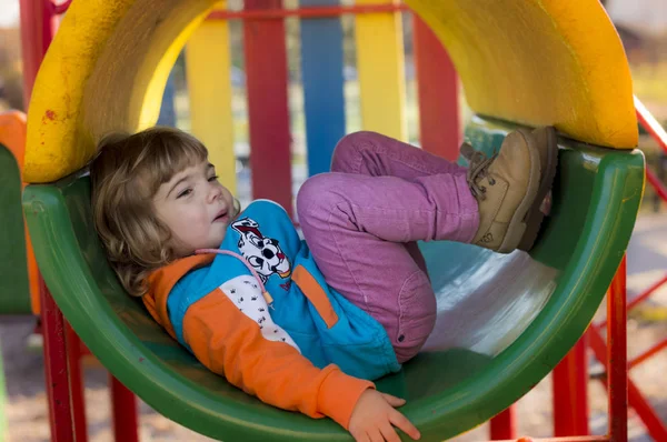 Menina brincando no playground Fotografias De Stock Royalty-Free