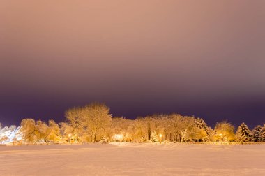Akşamları karla kaplı kış parkı