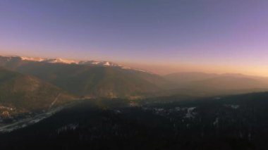 Kış günbatımı üzerinde dağ şehir