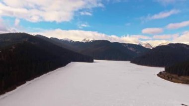 ağaçlar ve dağ gölü Bolboci karlı zirveleri