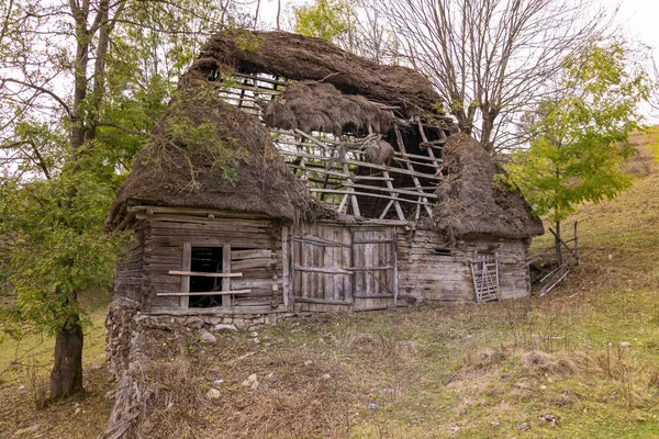 Небольшой деревянный дом с оттаявшей крышей в горах — стоковое фото