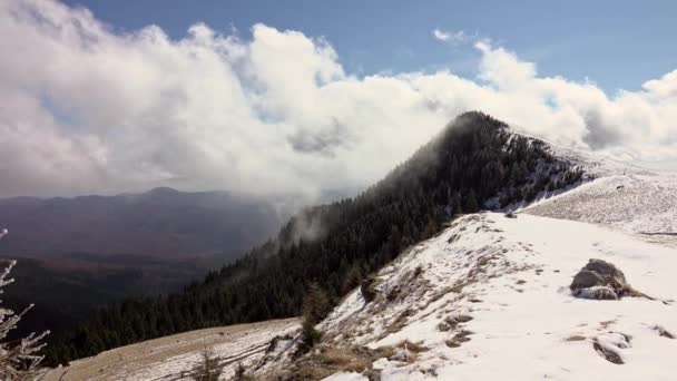 Neige et nuages mouvants dans les montagnes d'hiver, dans une journée de ciel bleu 