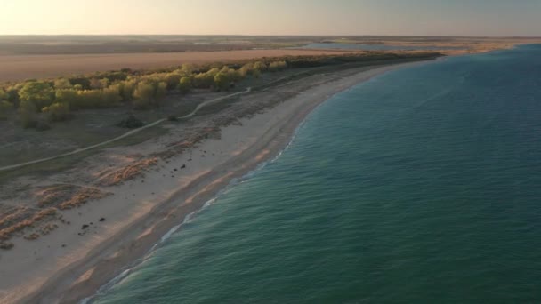 Vol aérien au-dessus de la belle plage sauvage vide sans fin avec des dunes de sable avant le coucher du soleil 