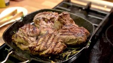 Izgara tavada baharatlı çiğ dana bifteğinin yakın çekim videosu.
